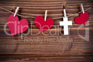 Colorful Hearts and a Cross Hanging on Wooden Background