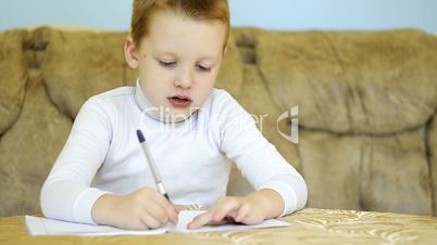 child writing alphabet at home