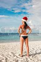 Woman in santa hat on the beach