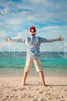 Man in santa hat on the tropical beach
