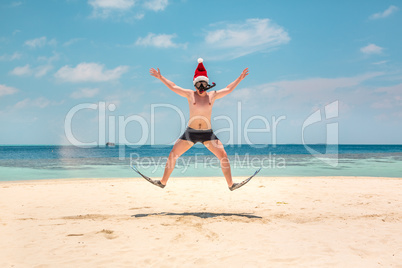 Man in santa hat on the tropical beach