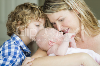 Young Mother Holds Newborn Baby Girl as Brother Looks On