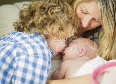 Young Mother Holds Newborn Baby Girl as Brother Looks On