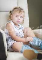 Blonde Haired Blue Eyed Little Girl Putting on Cowboy Boots