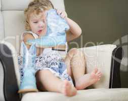 Blonde Haired Blue Eyed Little Girl Putting on Cowboy Boots