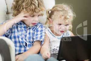 Young Brother and Sister Using Their Computer Laptop Together