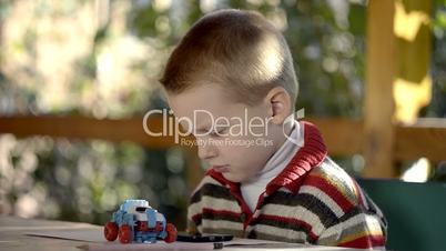 a boy plays on a smart phone outdoor