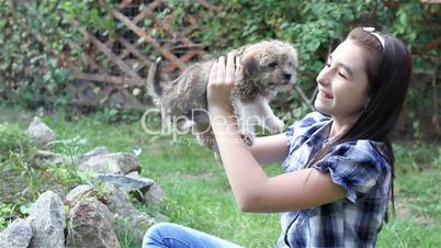 Girl cuddling a puppy outdoors