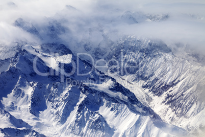 Top view on snow mountains and glacier in mist