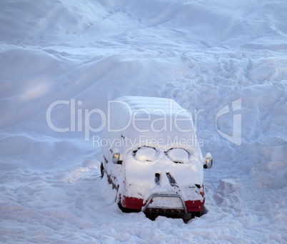 Snow-covered car with smiley in windshield