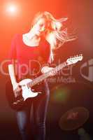 Frau auf einer Bühne spielt E-Gitarre