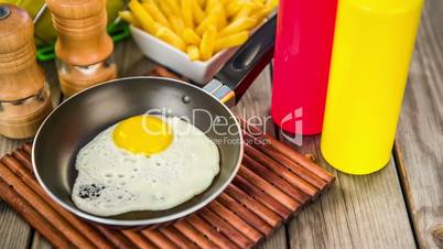 Fried eggs on a wooden table, breakfast