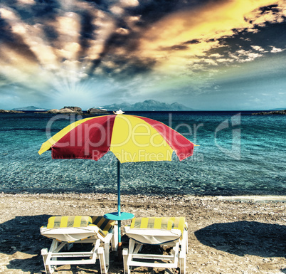 Colourful beach chairs with straw umbrellas on a beautiful sandy