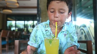 Child  in a cafe drinking lemonate