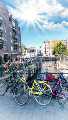 Amsterdam. Colourful yellow and pink Bicycles over the Canal