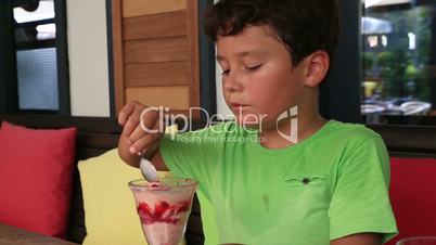 Child eating ice cream and smiling to a camera