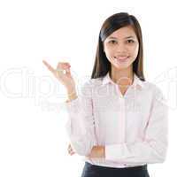 Asian business woman pointing on copy space