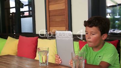 Child using digital tablet at the restaurant