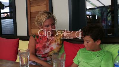 Mother and son sitting at cafe and talking