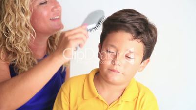 Mother combing son's hair