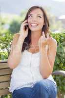 Young Adult Female Talking on Cell Phone Outdoors on Bench