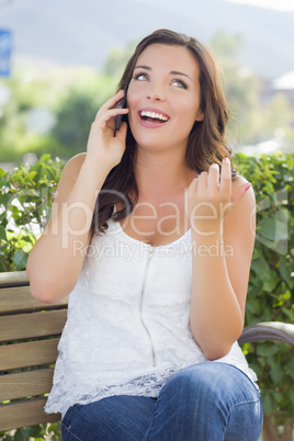 Young Adult Female Talking on Cell Phone Outdoors on Bench