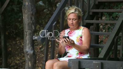 Woman sitting on park  and talking on cell phone
