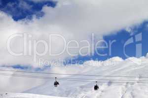 Gondola lifts and off-piste slope at sun day