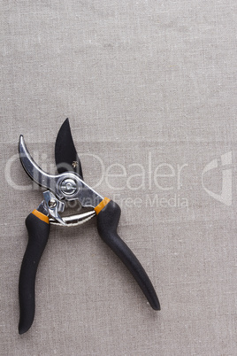Garden scissors on a gray fabric