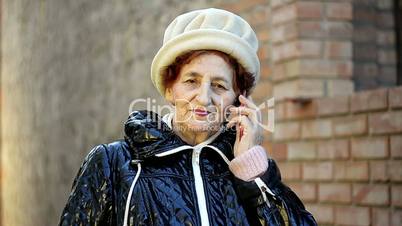 senior woman making a phone call with her mobile phone outdoor