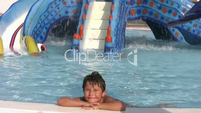 Child in aqua park smiling to a camera