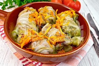 Cabbage stuffed with sauerkraut in ceramic pan on board