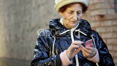 close up of senior woman using mobile phone outdoor