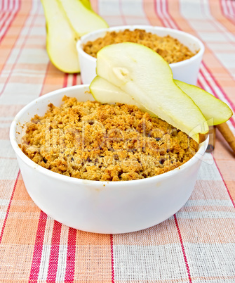 Crumble with pears in bowl on linen tablecloth