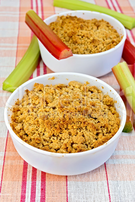 Crumble with rhubarb in two bowls on linen tablecloth