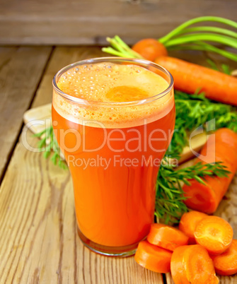 Juice carrot with leaf on board