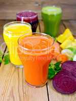 Juice vegetable in four glasses on wooden board