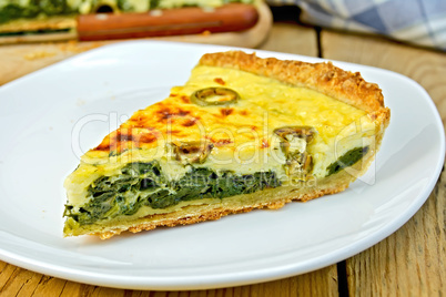 Pie with spinach and cheese in plate on table