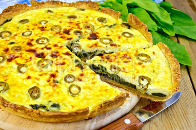 Pie with spinach and olives on board