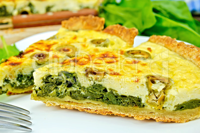 Pie with spinach and olives on plate