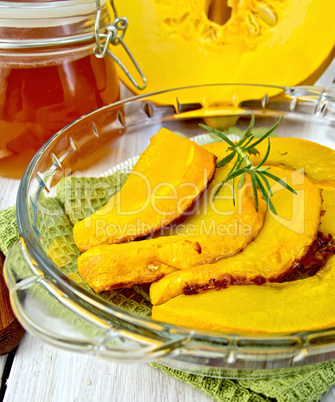 Pumpkin baked in glass pan with honey on board