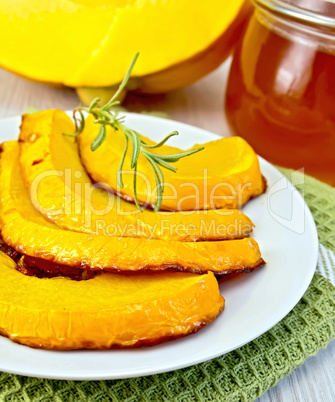 Pumpkin baked with honey in bowl on board