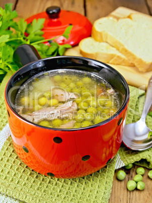 Soup from green peas with meat in red bowl