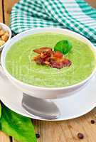 Soup puree with bacon and spoon on board