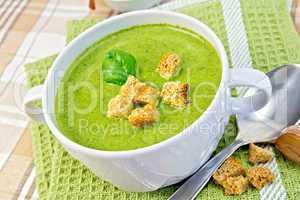 Soup puree with croutons and spinach leaves on napkin
