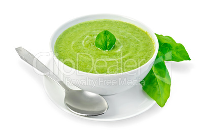 Soup puree with spinach in a bowl and leaves