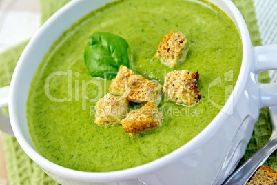 Soup puree with spinach leaves and croutons on napkin