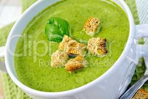 Soup puree with spinach leaves and croutons on napkin