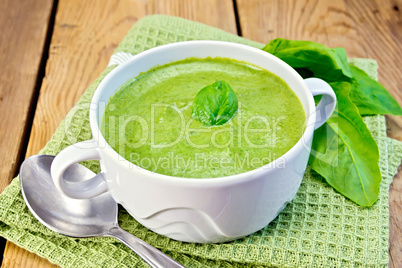 Soup puree with spinach leaves on board