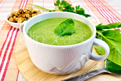 Soup puree with spinach leaves on fabric